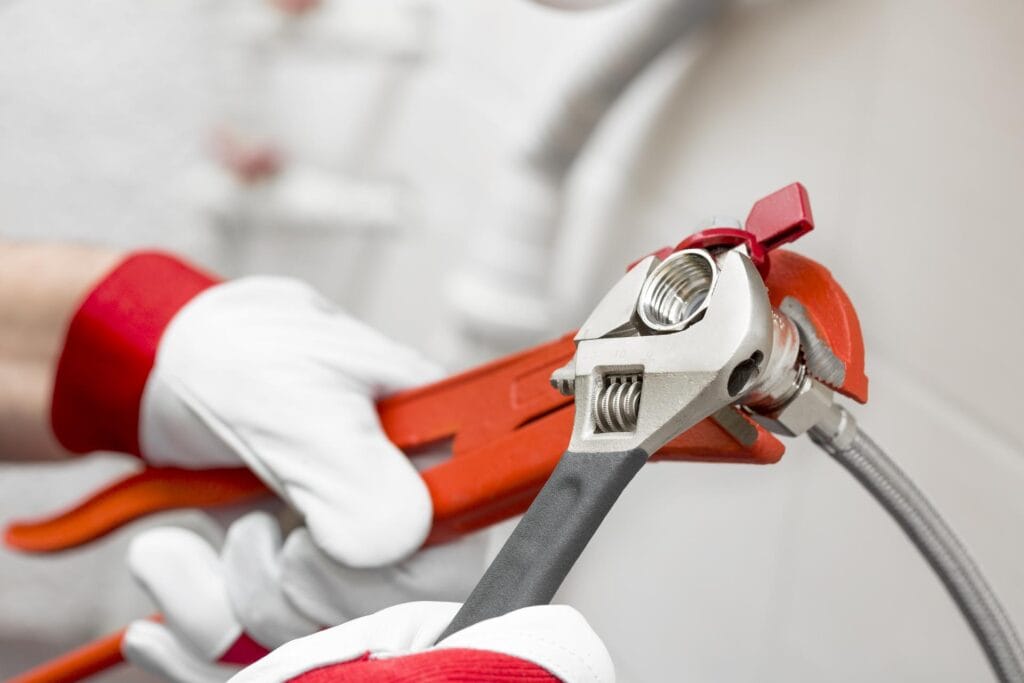 Plumber holding pipe wrenches for an emergency repair in Springfield