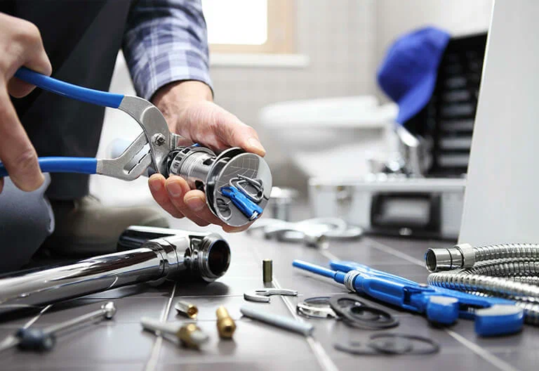 Technician repairing a plumbing fixture with professional tools in Springfield
