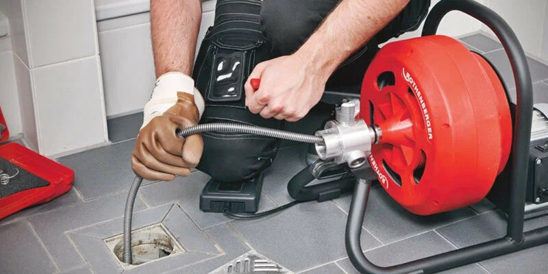 Plumber using a drain-cleaning machine in Springfield