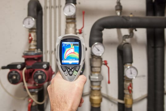 Plumber using a thermal imaging camera to inspect pipes in Springfield