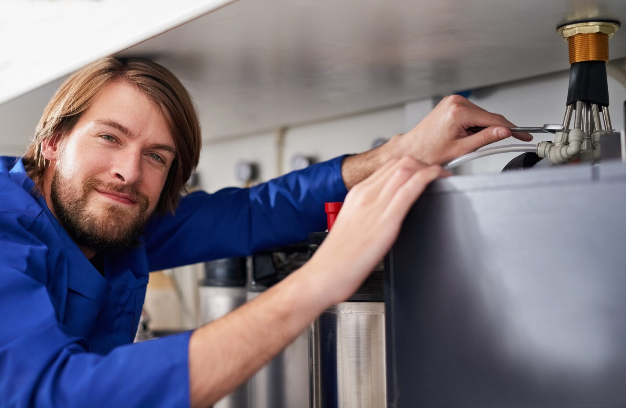Technician servicing a residential water heater tank in Springfield